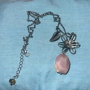 This is a silver necklace with a stone at the bottom.